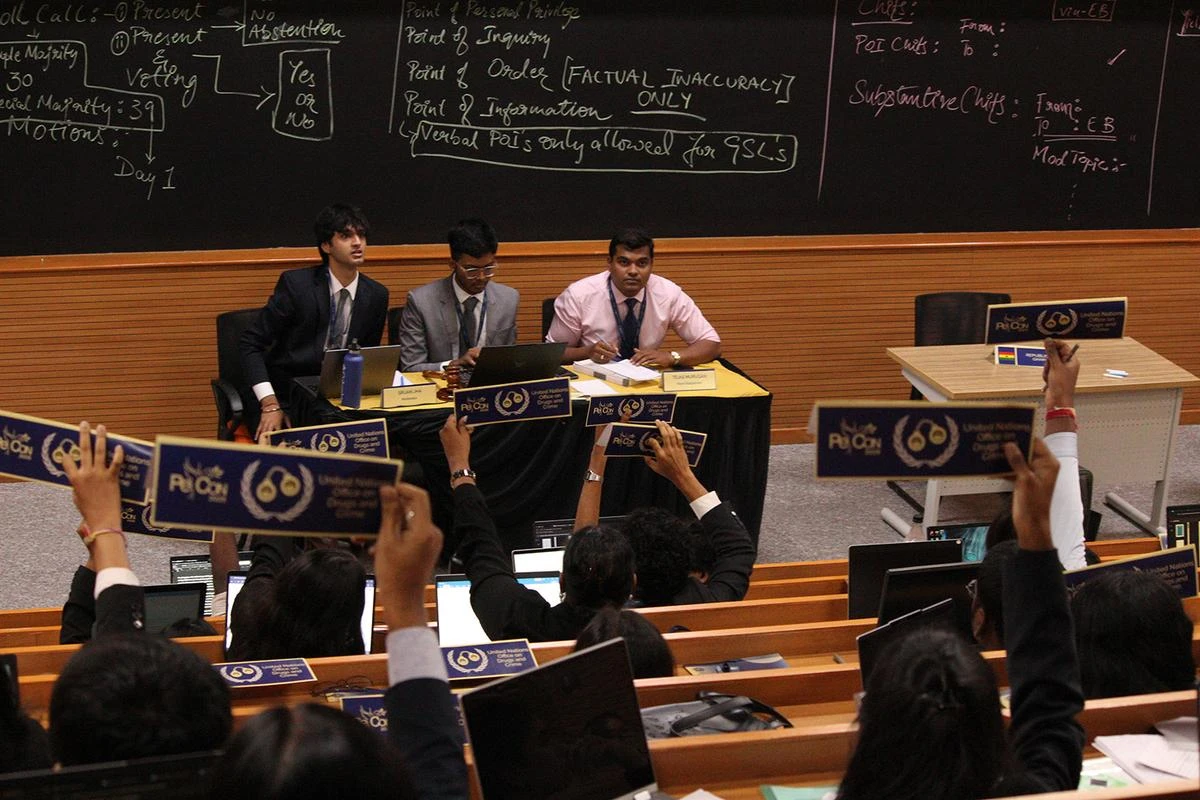 Delegates raising placards in the UNODC committee at PeCon 2025